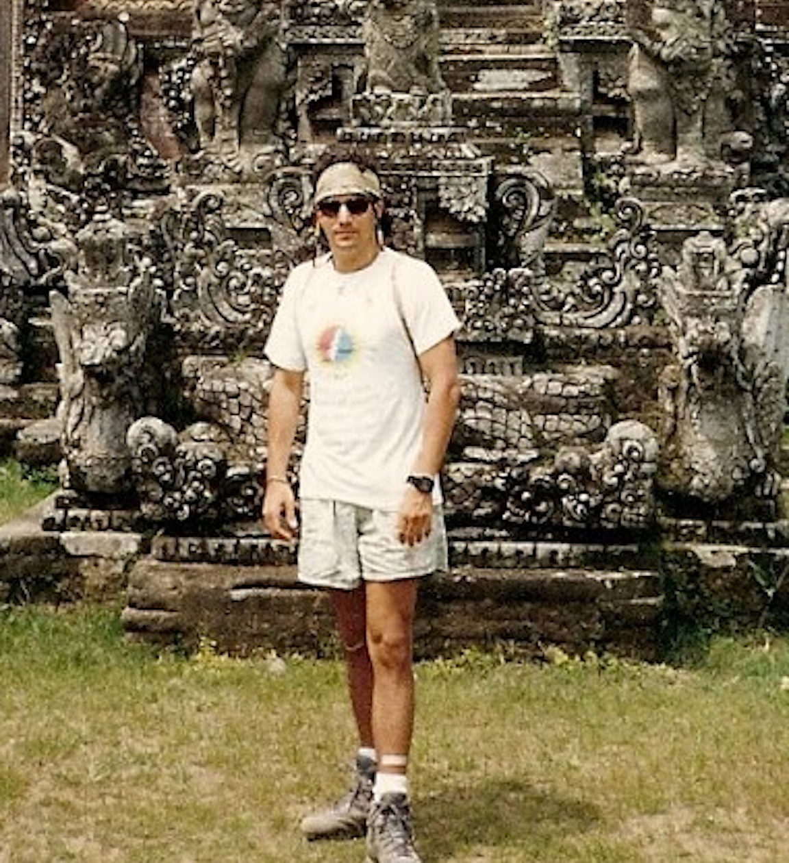 A photo of a person standing in front of a sculpture.